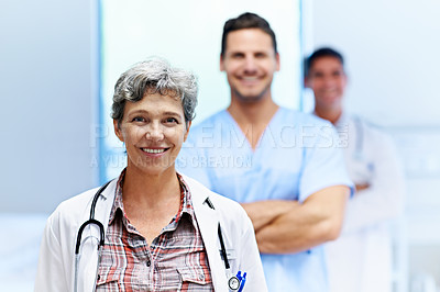 Buy stock photo Portrait of a confident doctor with medical staff in the background