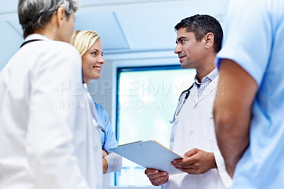 Buy stock photo Shot of a team of doctors having a discussion in a hospital
