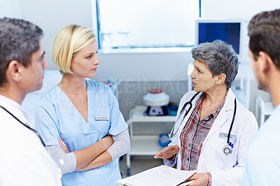 Buy stock photo Shot of a team of doctors having a discussion in a hospital