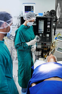 Buy stock photo Shot of surgeons in the operating room with a patient