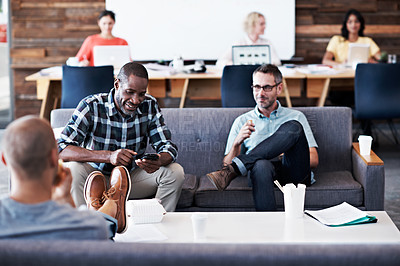 Buy stock photo Shot of three businessmen in an office with their female colleagues in the background