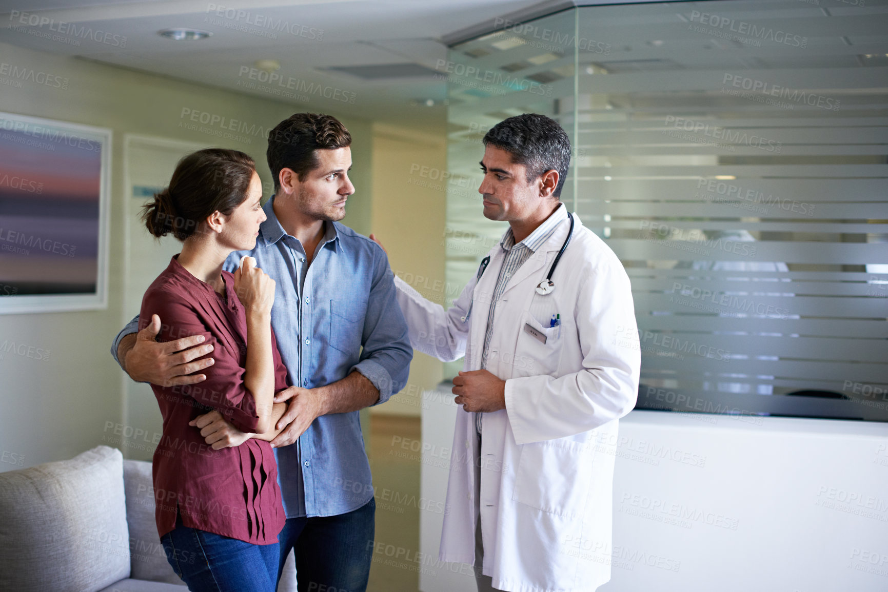 Buy stock photo Grief, couple and doctor in lobby of hospital for healthcare discussion, feedback or review. Anxiety, concern and medical professional speaking to sad people in clinic waiting room for bad news