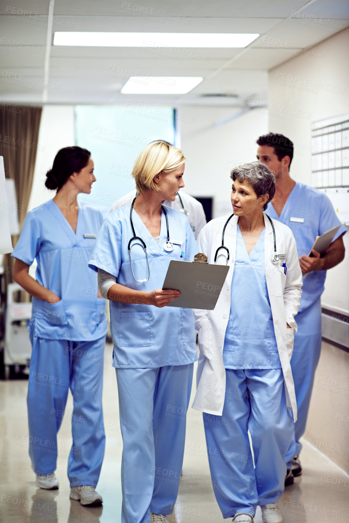 Buy stock photo Clipboard, hospital and doctors walking in corridor for discussion, patient report and consulting. Healthcare, nurses and people in hallway for talking, surgery advice and meeting for medical service