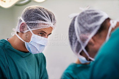 Buy stock photo Shot of a group of surgeons at work in an operating theater