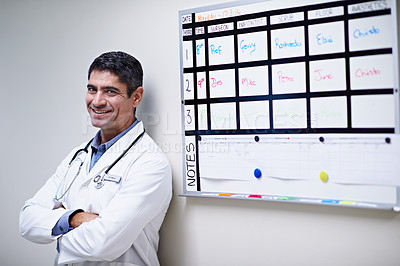 Buy stock photo Portrait of a doctor standing by a shift schedule in a hospital