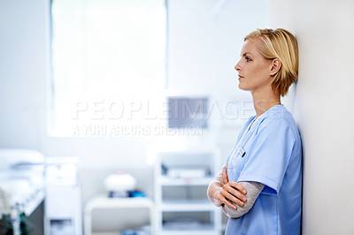 Buy stock photo Shot of a young female doctor standing in a hospital corridor
