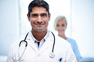 Buy stock photo Portrait of a male doctor with a colleague in the background