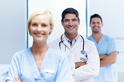 Buy stock photo Portrait of three confident doctors standing together in a hospital