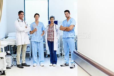 Buy stock photo Portrait of a group of doctors standing in a hospital corridor