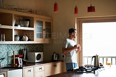 Buy stock photo Shot of man looking thoughtful while having his morning coffee