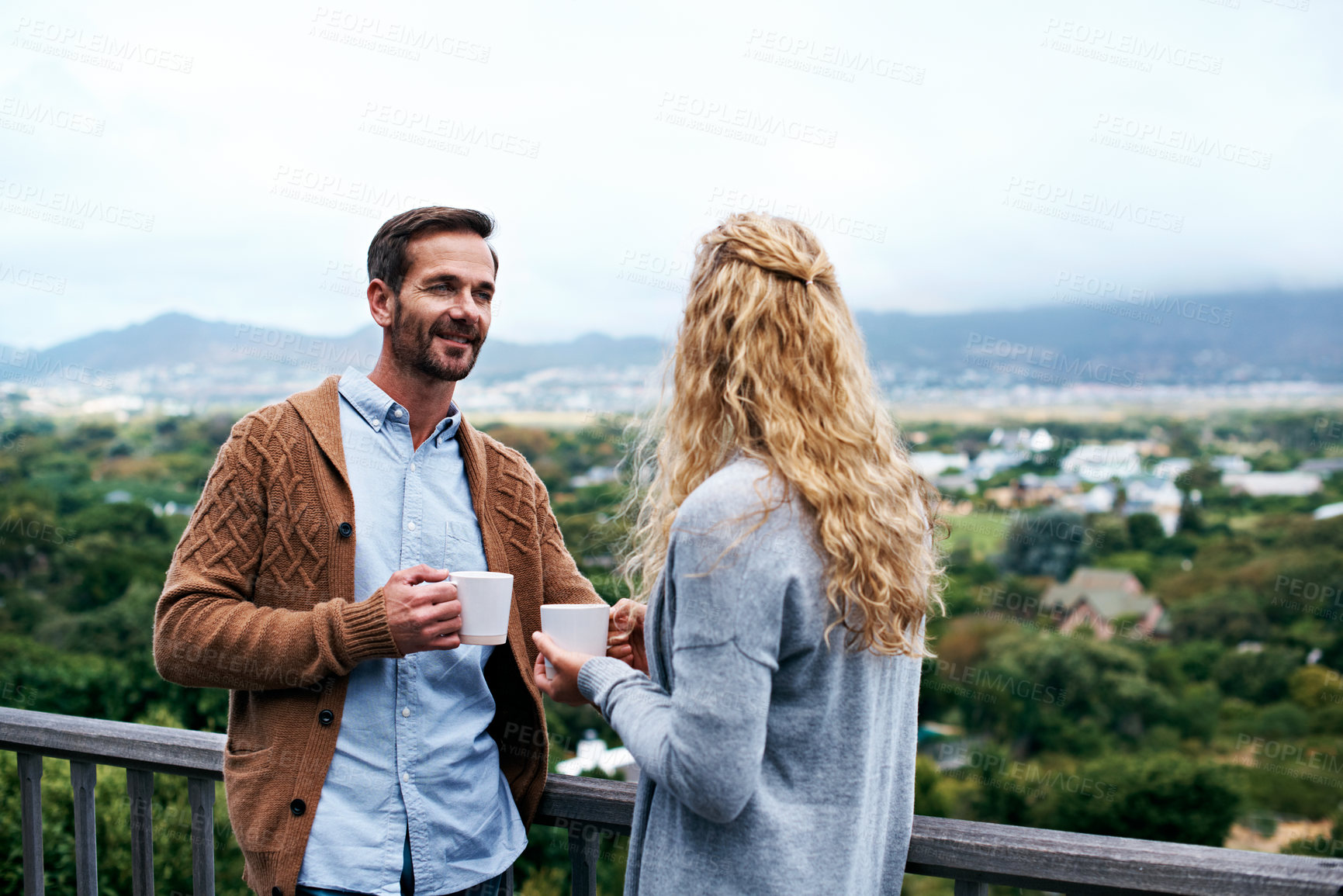 Buy stock photo Shot of a couple having a conversation on a balcony