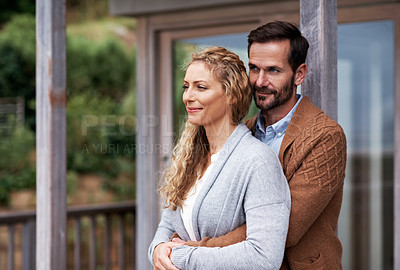 Buy stock photo Shot of an affectionate couple standing on a balcony