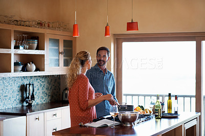 Buy stock photo Shot of a happy couple preparing a meal at home