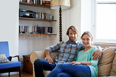 Buy stock photo Shot of a loving young couple relaxing on a sofa at home