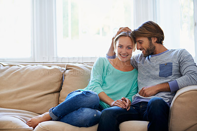 Buy stock photo Shot of a loving young couple relaxing on a sofa at home