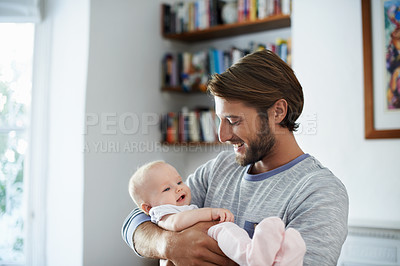 Buy stock photo Shot of a smiling father playing with his baby girl at home