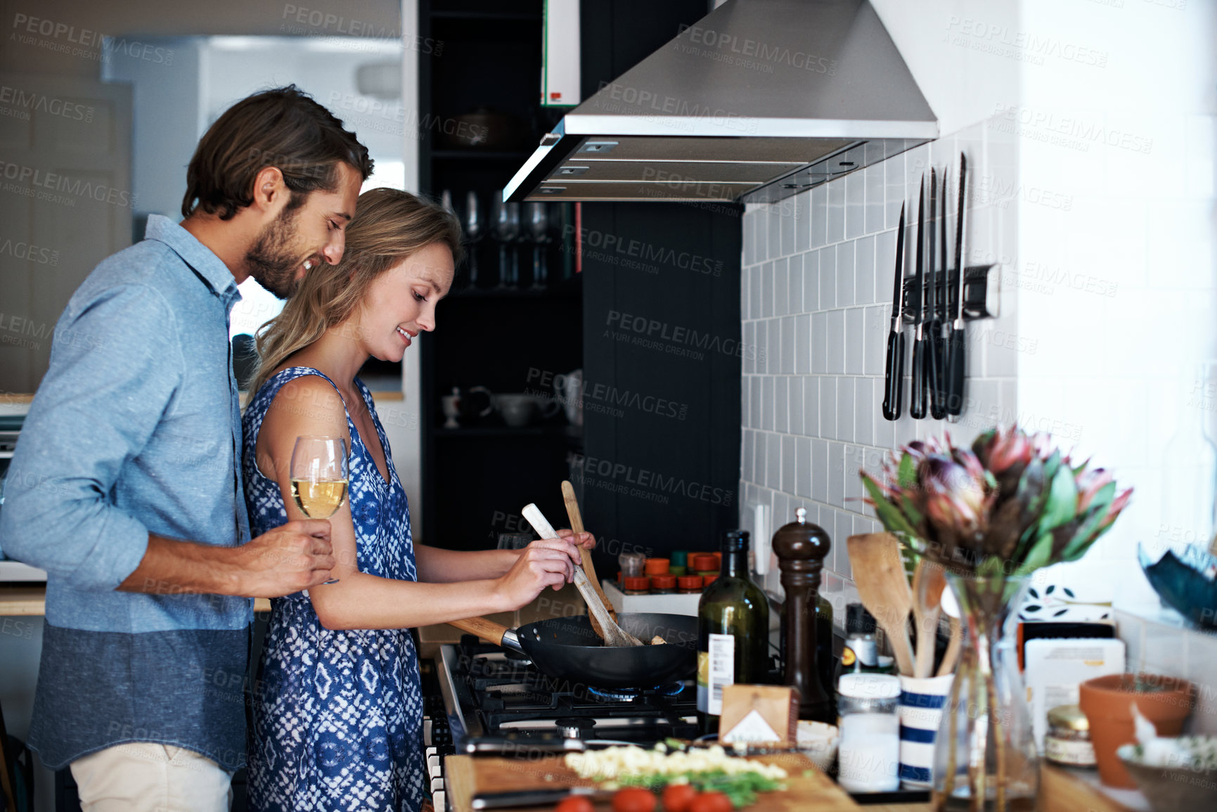 Buy stock photo Shot of a young couple cooking together in the kitchen