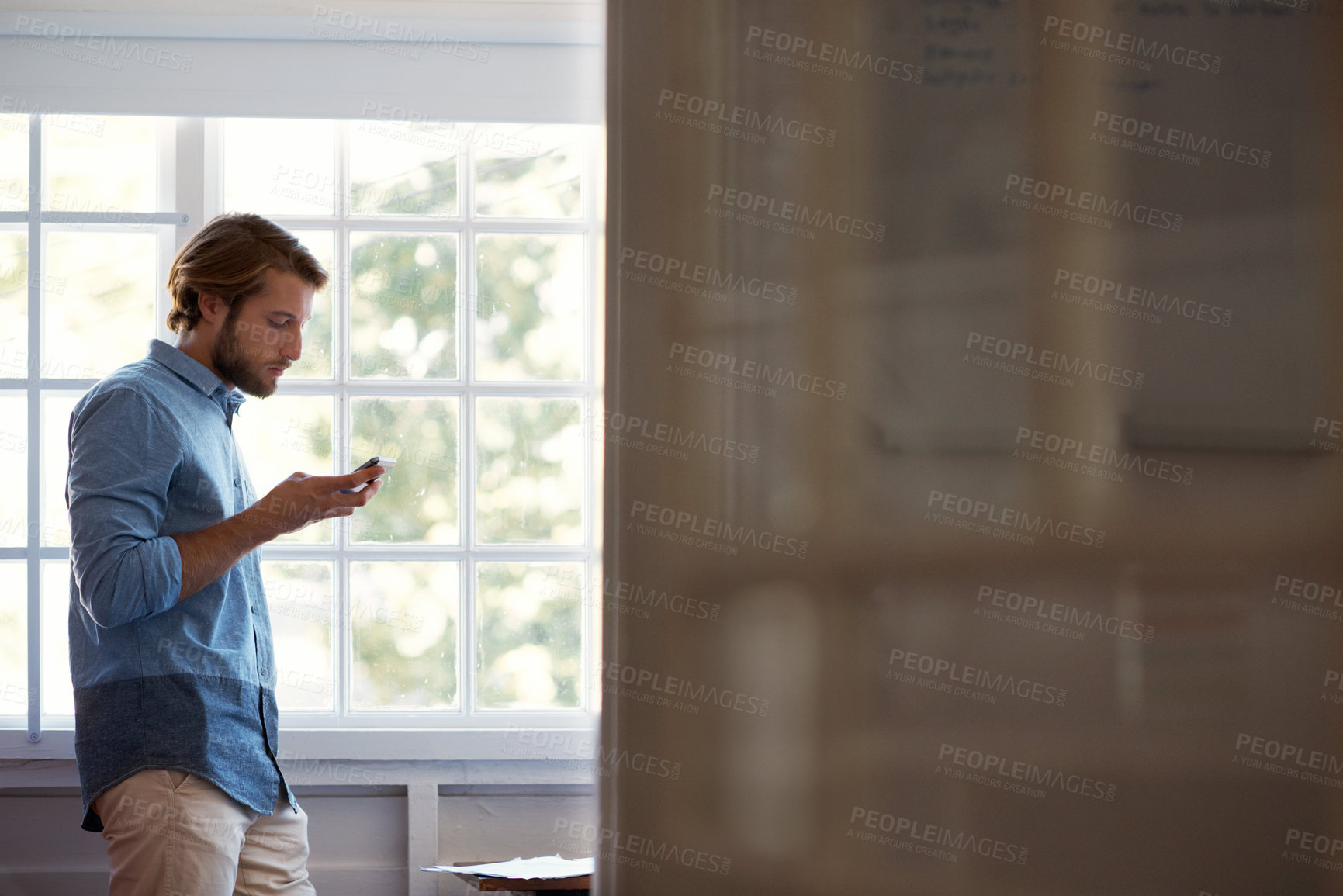Buy stock photo Shot of a man using his cellphone at home