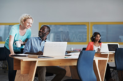 Buy stock photo Shot of a woman assisting her coworker with their colleague blurred in the background