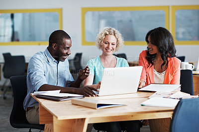 Buy stock photo Cropped shot of three businesspeople working on a laptop