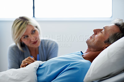 Buy stock photo Shot of a woman comforting her husband lying in a hospital bed