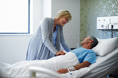 Buy stock photo Shot of a woman comforting her husband lying in a hospital bed