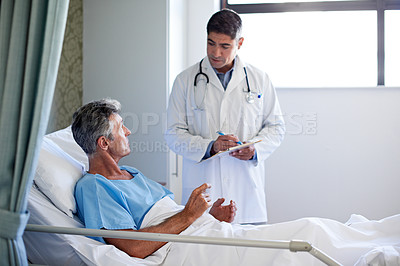Buy stock photo Shot of a doctor having a conversation with a patient lying in a hospital bed