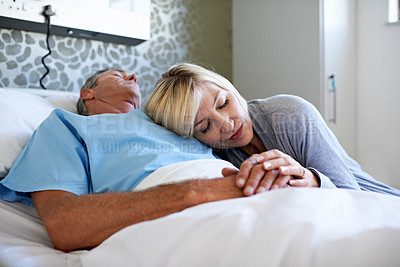 Buy stock photo Shot of a wife visiting her sleeping husband in the hospital