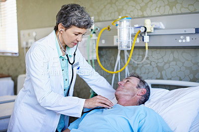 Buy stock photo Shot of a doctor doing test on a patient lying in a hospital bed