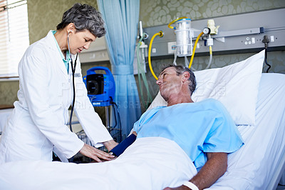 Buy stock photo Shot of a doctor doing test on a patient lying in a hospital bed