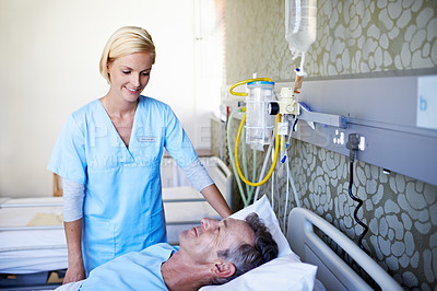 Buy stock photo Shot of a nurse talking to a patient in a hospital ward