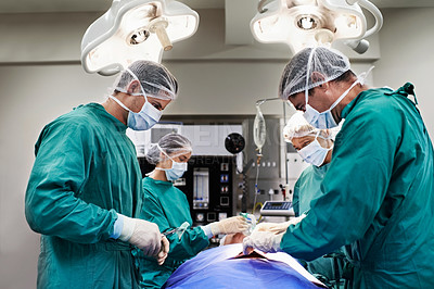 Buy stock photo Shot of a team of surgeons performing an operation