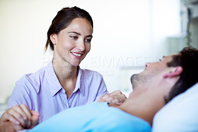 Buy stock photo Shot of a woman visiting her husband recuperating in a hospital