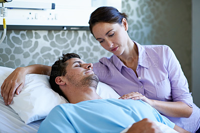 Buy stock photo Shot of a woman visiting her husband recuperating in a hospital