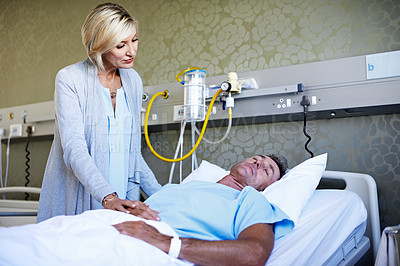 Buy stock photo Shot of a wife visiting her sleeping husband in the hospital