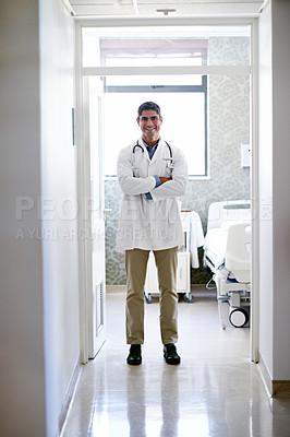 Buy stock photo Portrait of a mature male doctor standing in a hospital ward