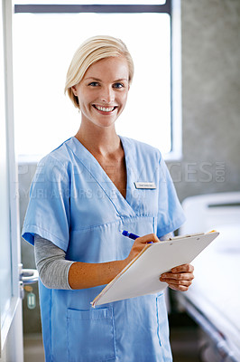 Buy stock photo Portrait of a young doctor with paperwork standing in a hospital ward