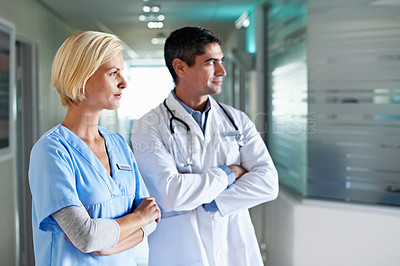 Buy stock photo Shot of two medical professionals standing in a hospital corridor