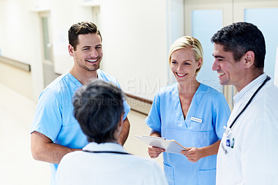 Buy stock photo Shot of a group of medical professionals having a discussion in a hospital corridor