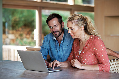 Buy stock photo Shot of a couple using a laptop at home