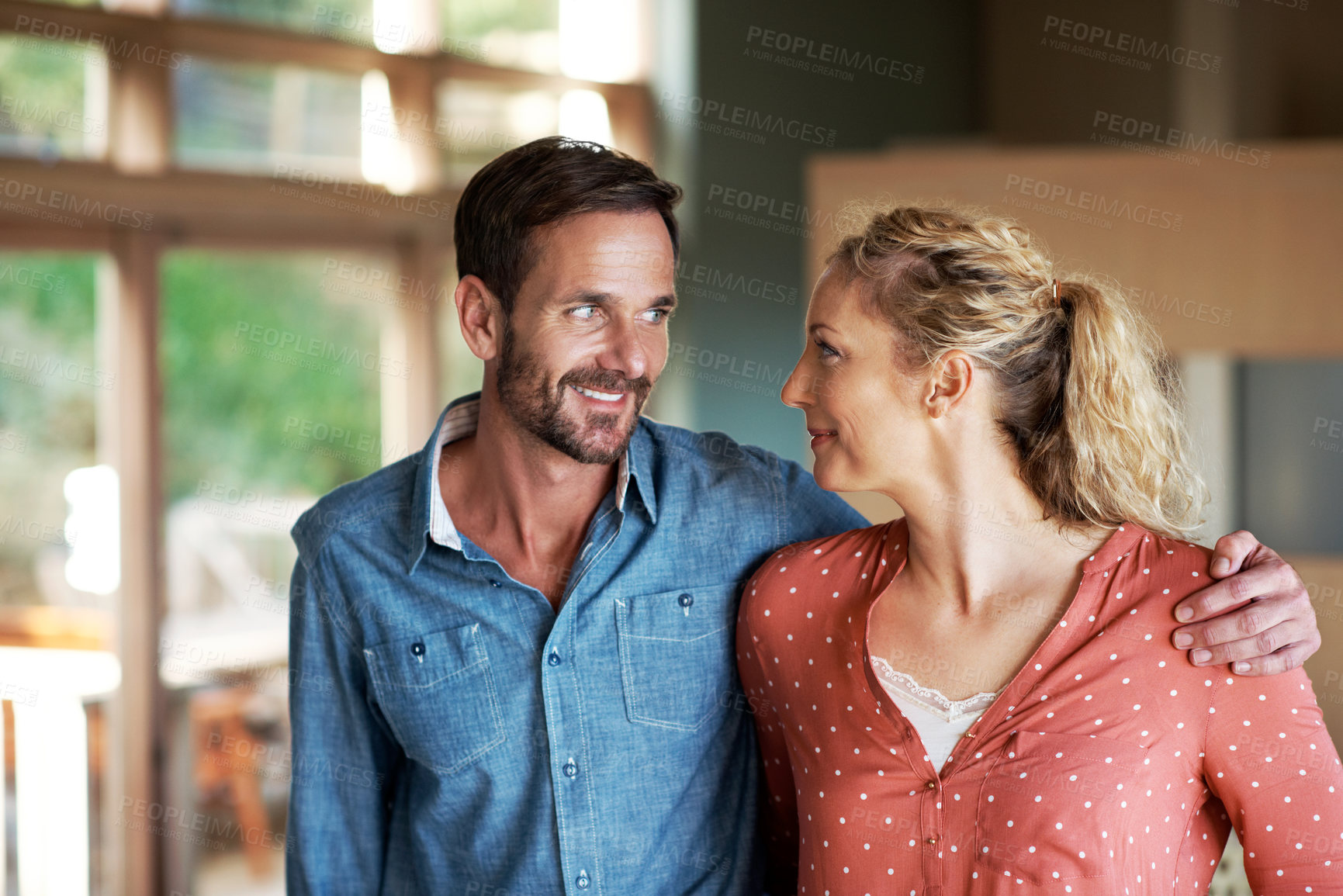 Buy stock photo Shot of a loving couple looking at each other  while spending time together at home