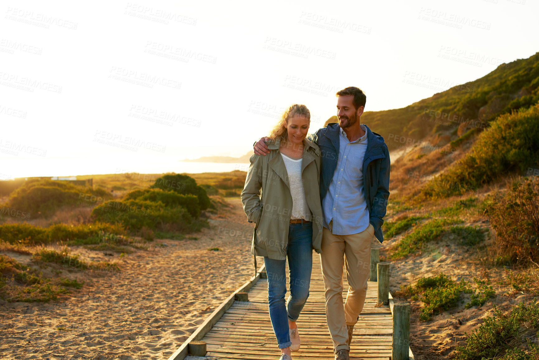 Buy stock photo Smile, couple and walking outdoor for travel, adventure and bonding on summer holiday. Space, happy and people in nature with embrace, partner affection and stroll on vacation getaway for fresh air