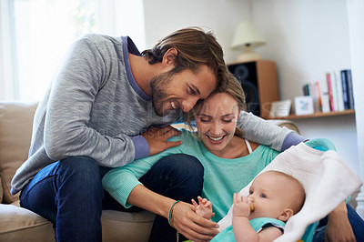 Buy stock photo Shot of a young couple playing with their baby at home