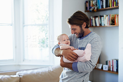Buy stock photo Shot of a smiling father playing with his baby girl at home