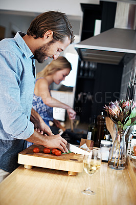 Buy stock photo Shot of a young couple cooking together in the kitchen