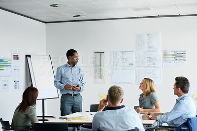 Buy stock photo Shot of a man giving a presentation to coworkers in an office