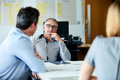 Buy stock photo Shot of three colleagues having a meeting in an office
