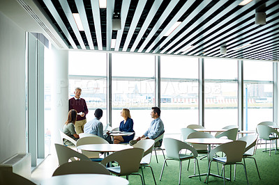 Buy stock photo Shot of a group of colleagues talking together in a modern office