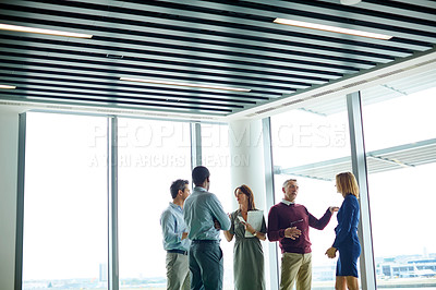 Buy stock photo Shot of a group of colleagues talking together in a modern office