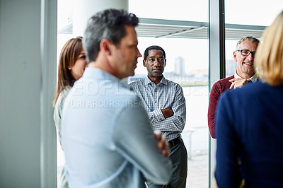 Buy stock photo Shot of a group of colleagues talking together in a modern office